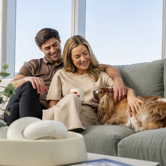 man and woman on couch with dog